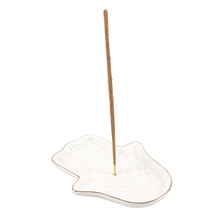 White ceramic Hamsa Hand incense holder styled with incense stick and natural décor, creating a calming atmosphere.