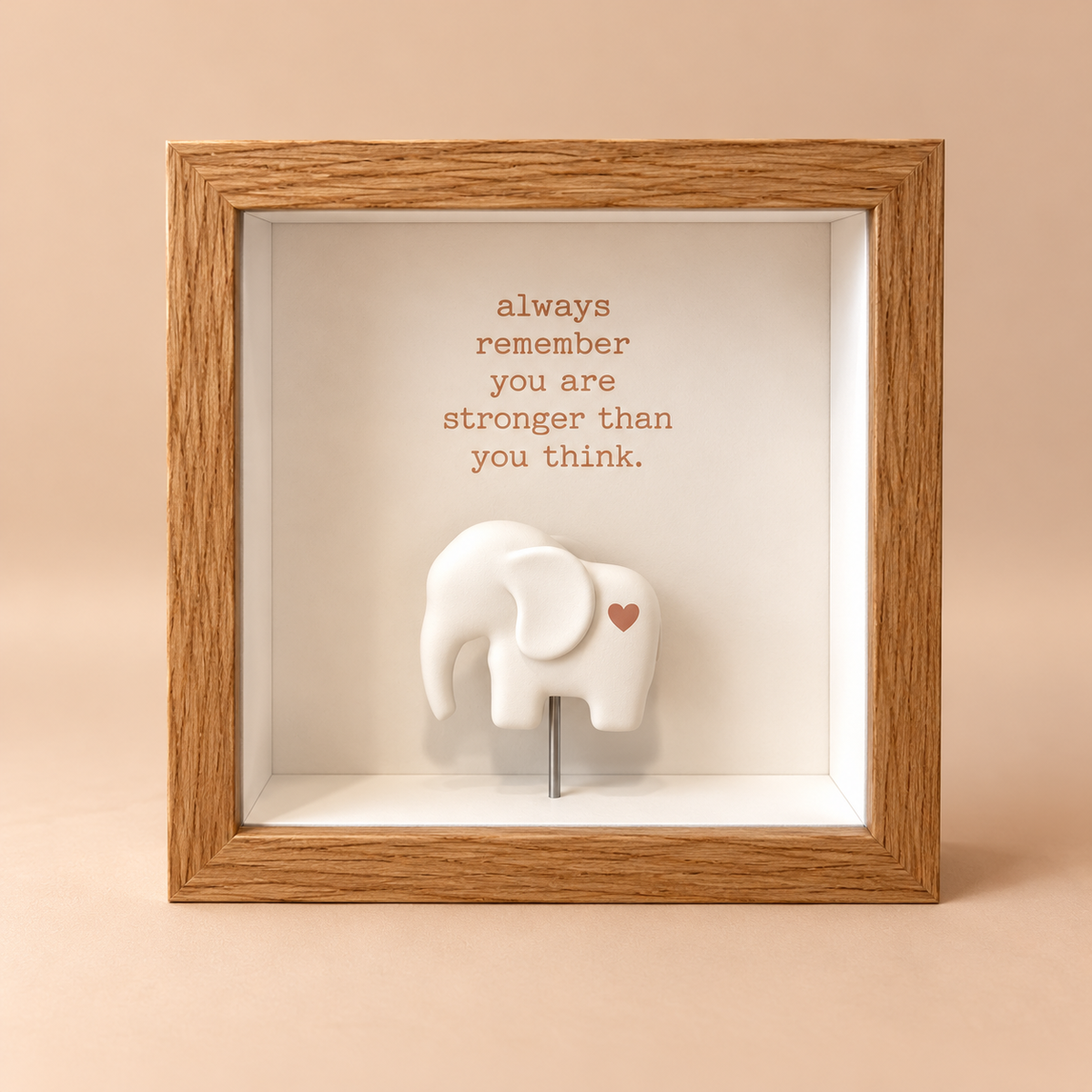 Square oak finish 3D shadowbox frame with the quote “always remember you are stronger than you think” above a raised white elephant.
