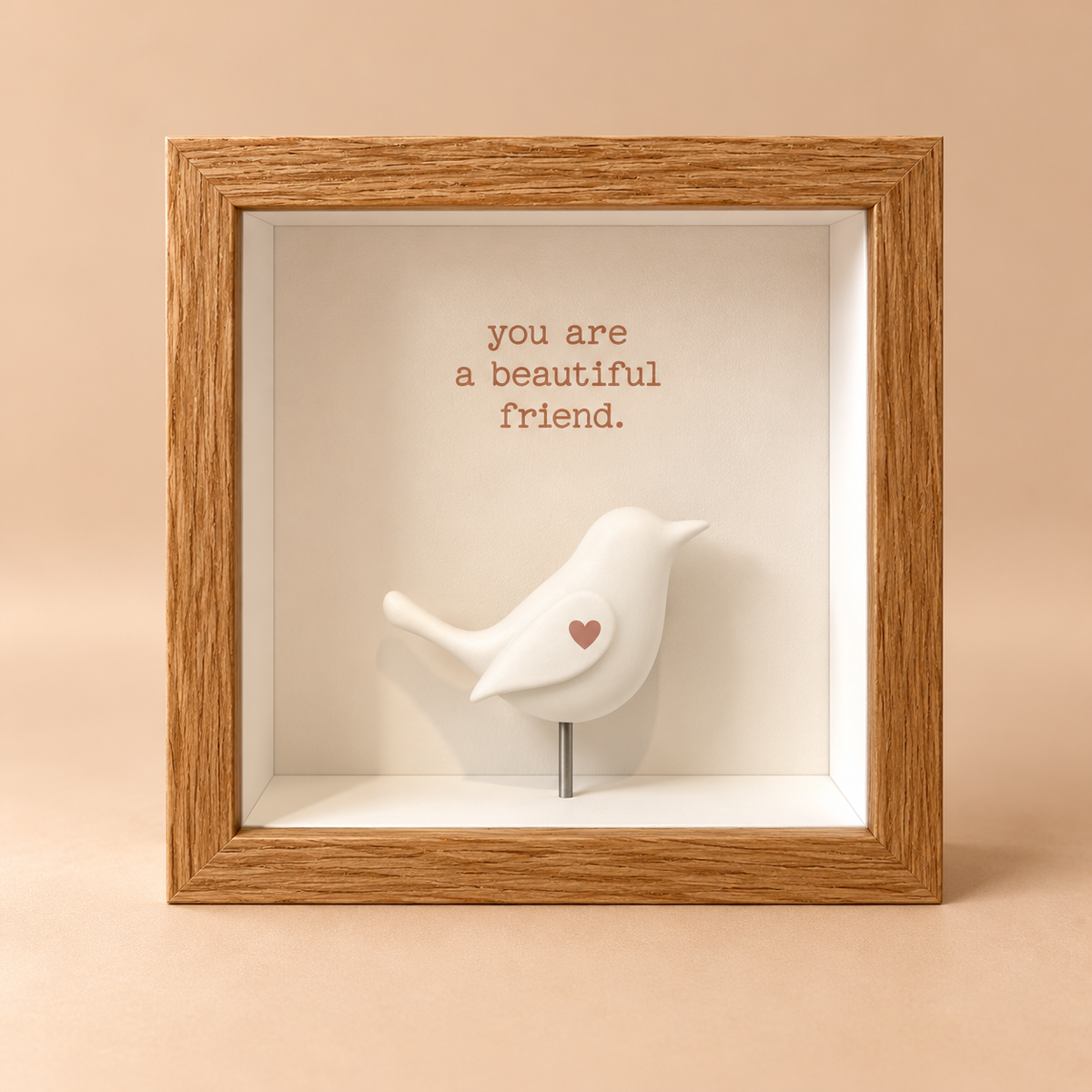 Square oak finish 3D shadowbox frame with the words “you are a beautiful friend” above a raised white bird figurine.