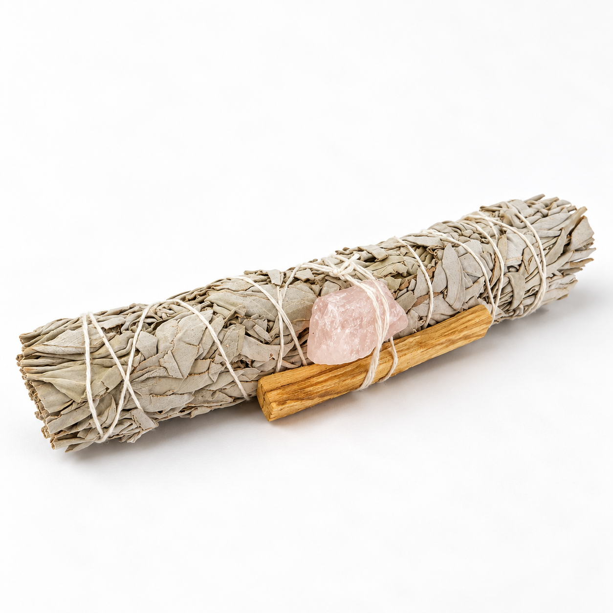 White Sage smudge stick tied with Palo Santo wood and Rose Quartz crystal in a ritual kit.