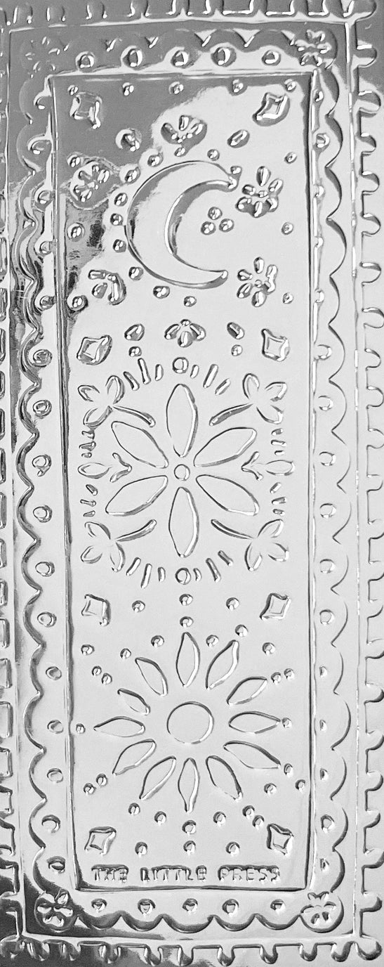 Faux-tin silver bookmark with embossed sun, moon and flower design