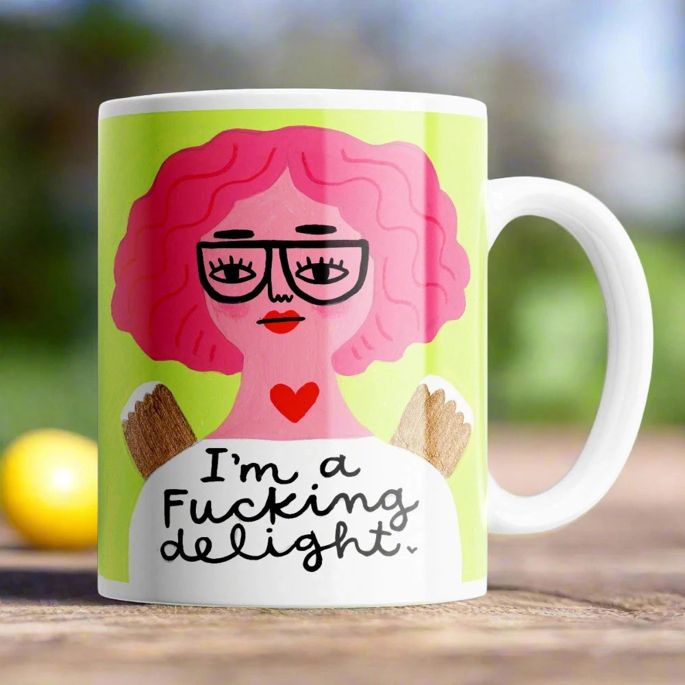 Humorous I’m a F**ing Delight* mug on table – cheeky 11 oz ceramic coffee cup gift.