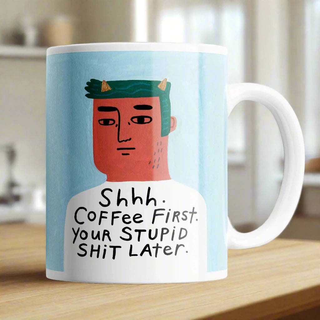 Humorous Shhh Coffee First mug on desk – cheeky 11 oz ceramic coffee cup gift.