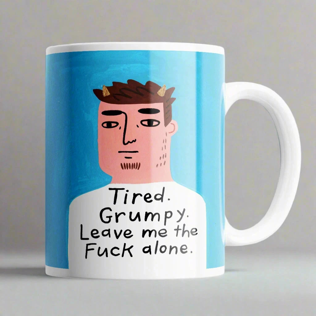 Humorous Tired Grumpy Leave Me the F** Alone* mug on table – cheeky 11 oz ceramic coffee cup gift.