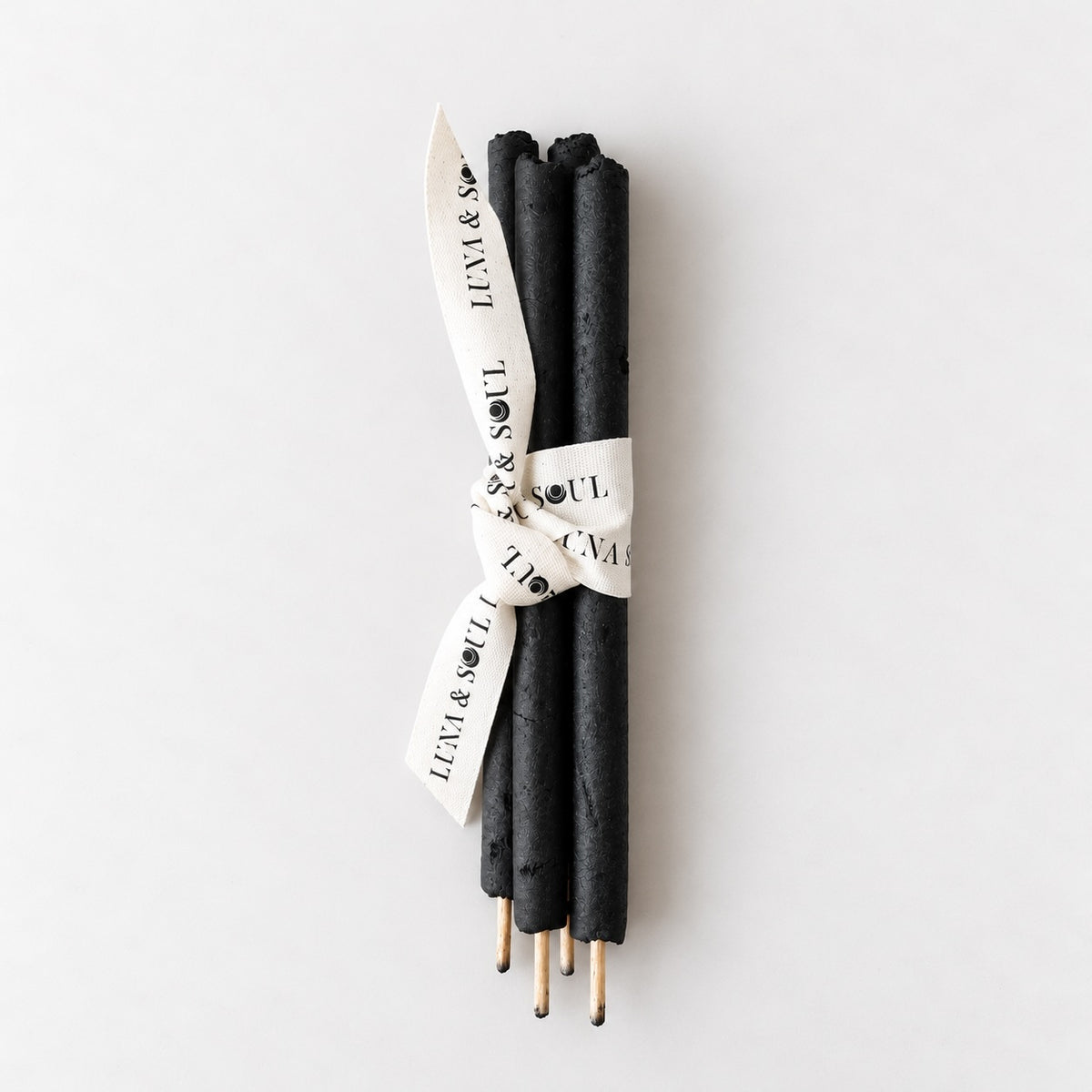 Four black hand-rolled Breuzinho resin and Palo Santo incense sticks presented together as a bundle.