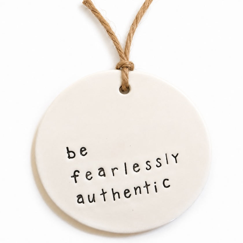 Luna and Soul Be Fearlessly Authentic handmade ceramic tag with jute twine on white background.