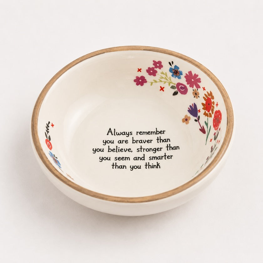 White ceramic affirmation bowl with floral details, natural edge rim and inspirational “Always remember you are braver than you believe, stronger than you seem and smarter than you think” quote.