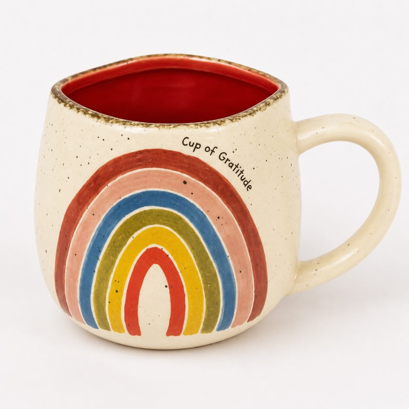 Speckled ceramic mug with colourful rainbow design, red interior and “Cup of Gratitude” text.