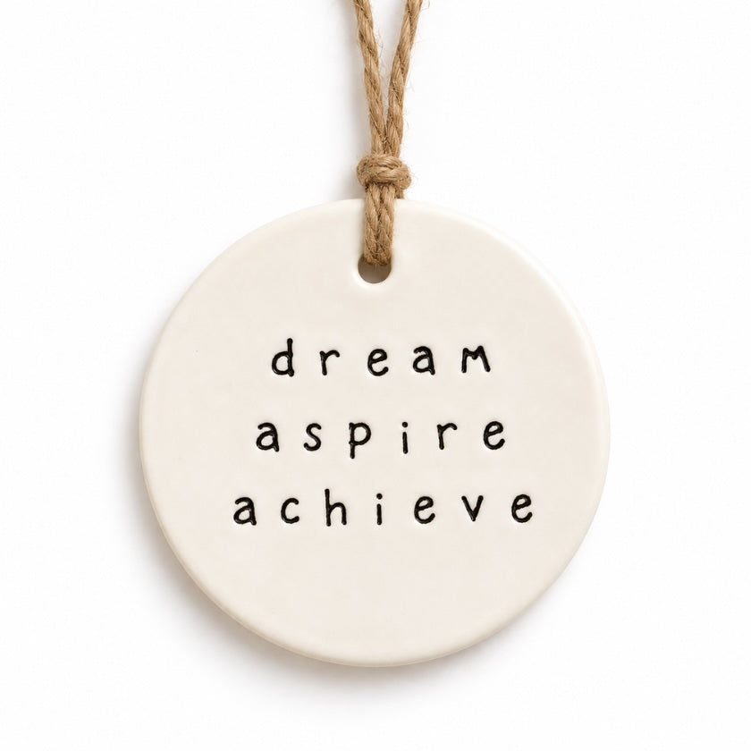 Cream round Dream Aspire Achieve ceramic tag with black and white hanging cord by Luna &amp; Soul.