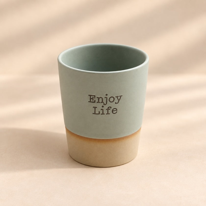 Enjoy Life hand-glazed ceramic mug in soft sage green with natural-toned base.