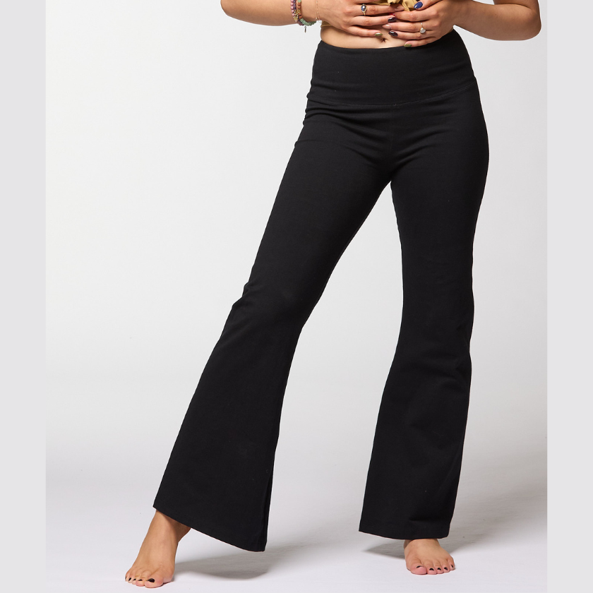 Woman wearing black organic cotton long leg flare yoga pants with high waisted fit against neutral studio background
