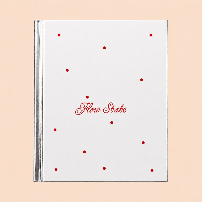 Flow State cycle syncing journal by Selfdom silver mirrored hardcover with red script lettering.