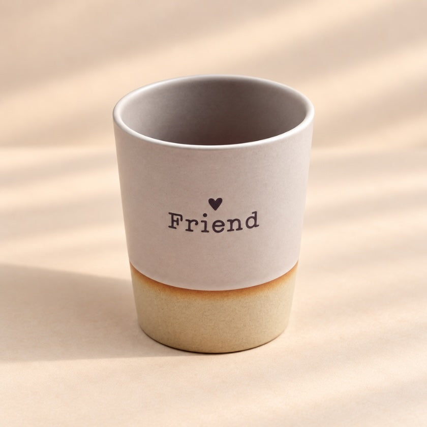 Friend hand-glazed ceramic mug in soft blush pink with heart detail and natural-toned base.