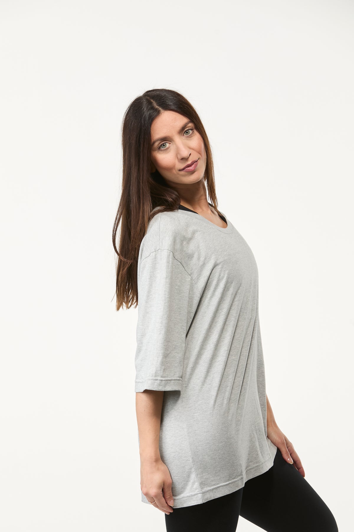 Side angle view of women’s grey oversized tee with soft drape and relaxed everyday fit
