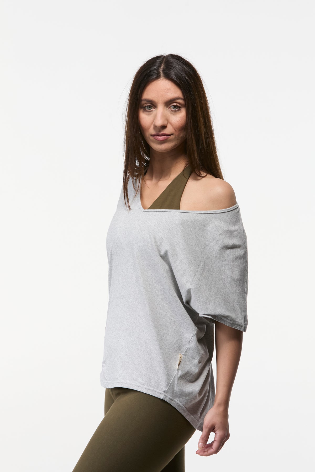 Woman wearing a grey V-neck relaxed shoulder yoga top with lightweight drape and flattering fit