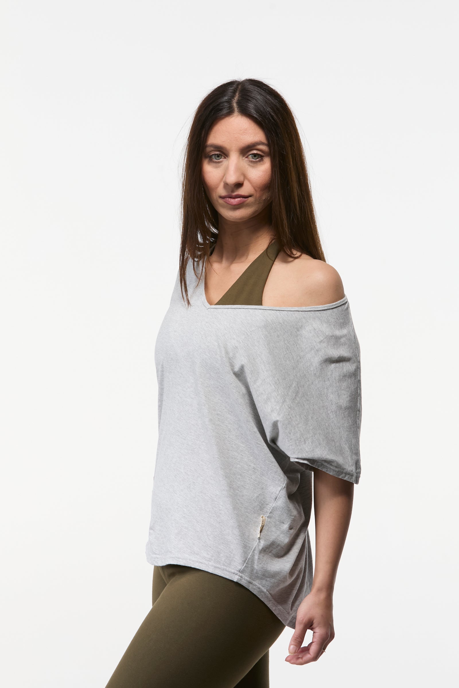 Woman wearing a grey V-neck relaxed shoulder yoga top with lightweight drape and flattering fit