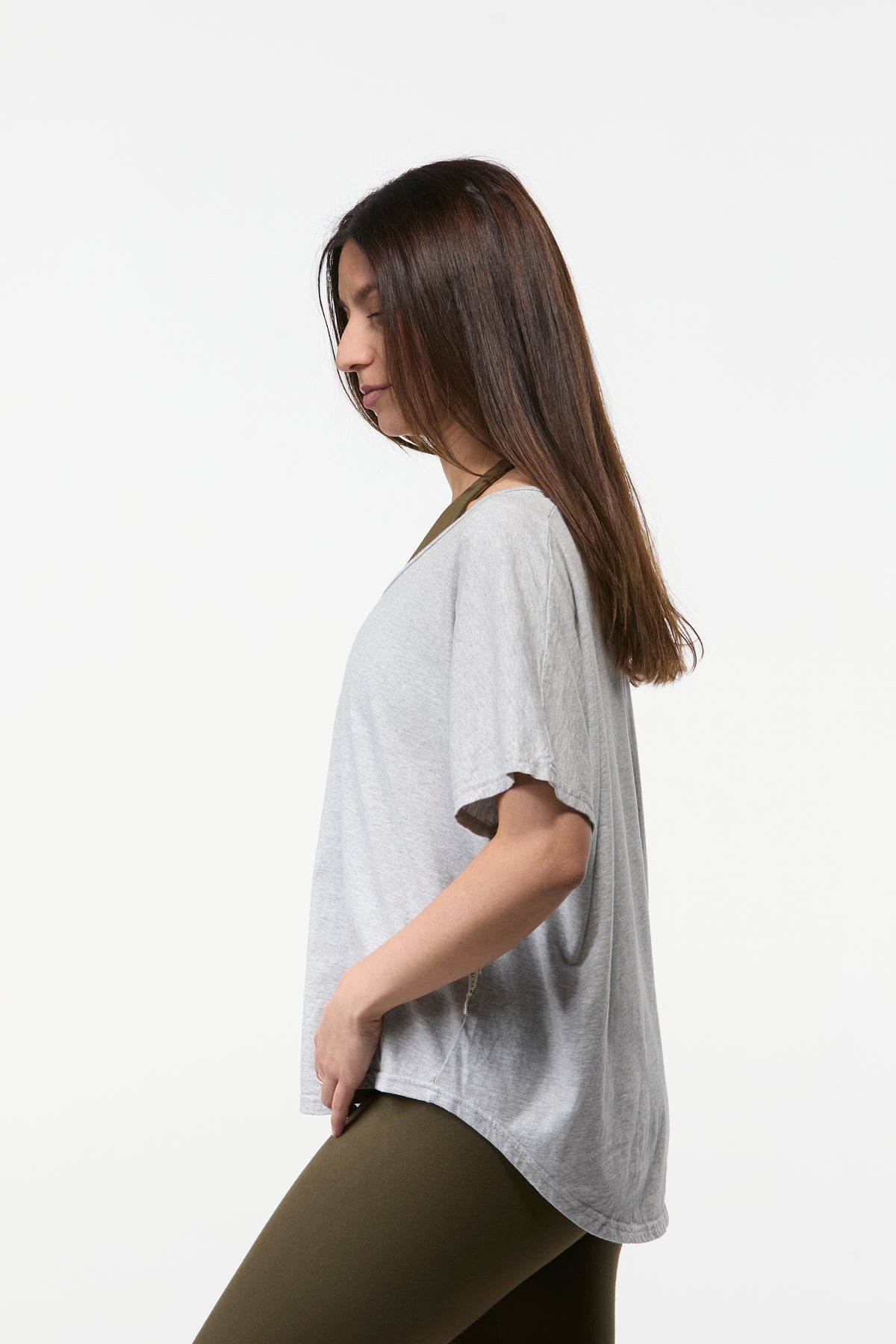 Side profile of grey V-neck relaxed yoga top for women with soft drape and casual styling