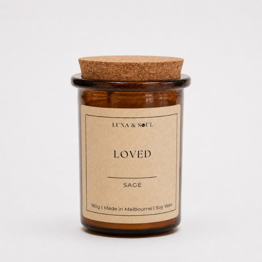 Luna &amp; Soul I Am Loved affirmation soy candle in amber glass with natural cork lid.