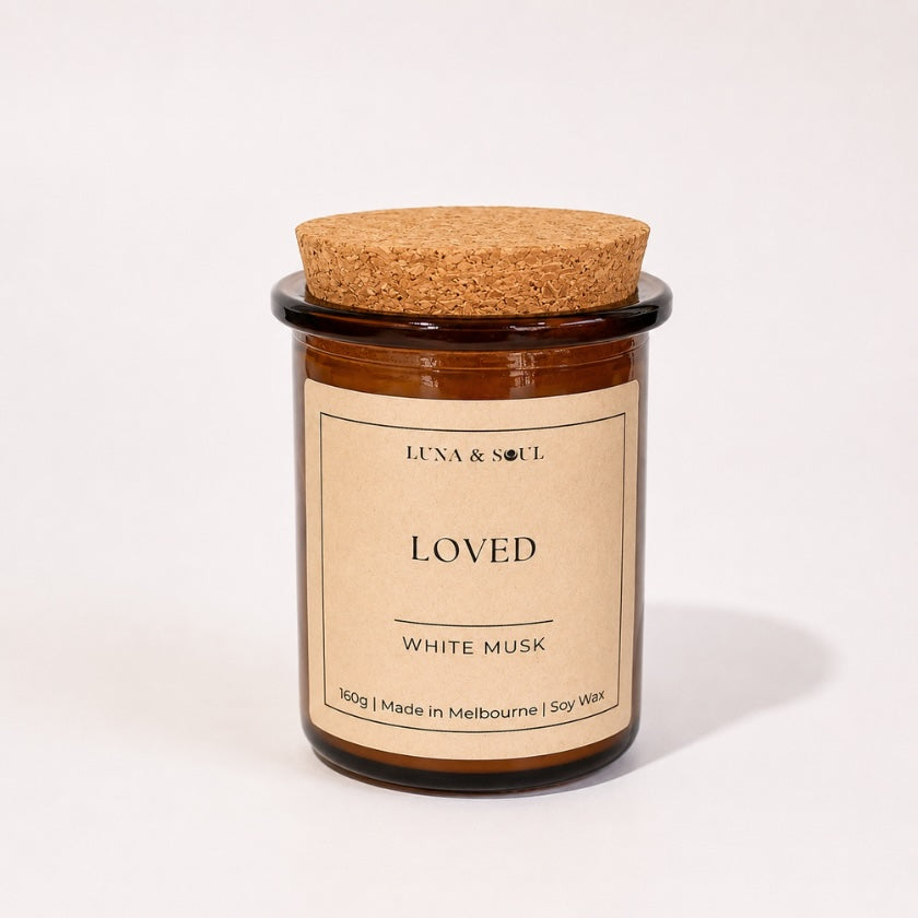 Luna &amp; Soul I Am Loved affirmation soy candle in amber glass with natural cork lid.