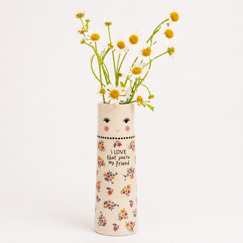 Ceramic floral vase with smiling face detail, delicate flower pattern and “I love that you’re my friend” quote, styled with fresh white daisies.