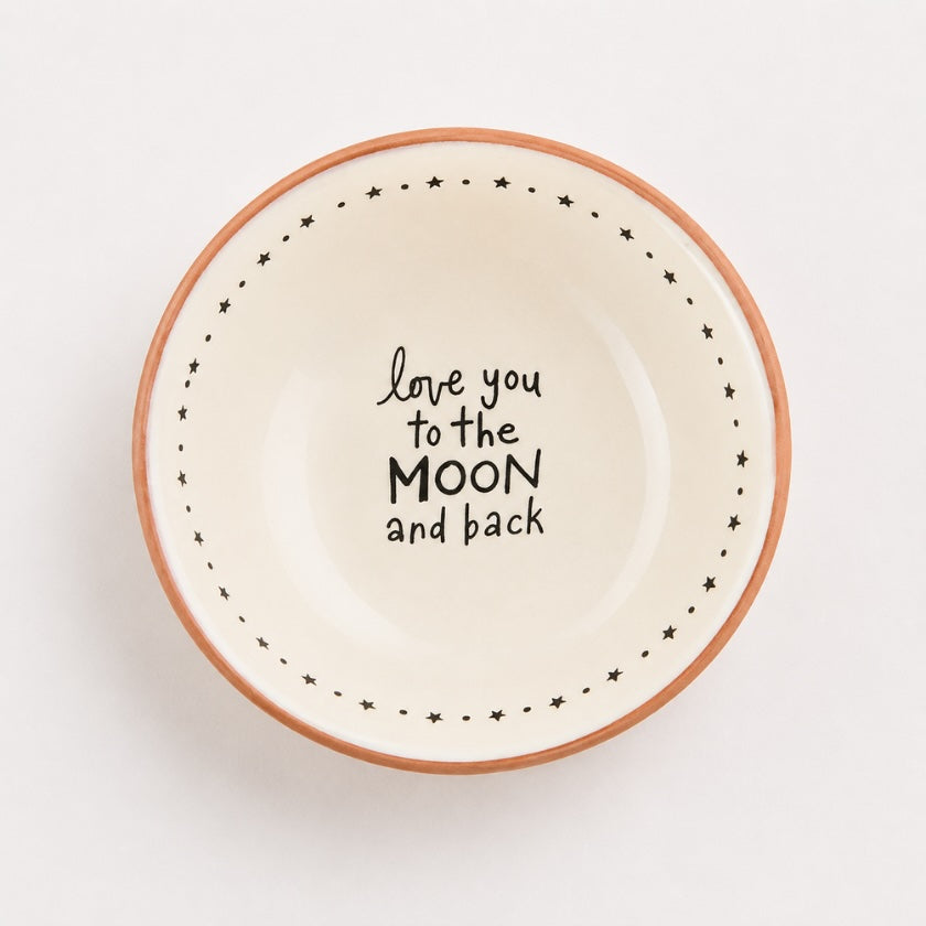 White ceramic trinket bowl with terracotta rim, star border detail and “Love you to the moon and back” quote in the centre.