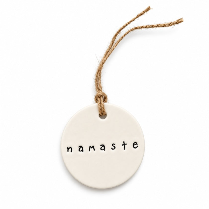 Handmade Namaste ceramic tag in natural glazed earthenware clay with jute twine, made in Australia.