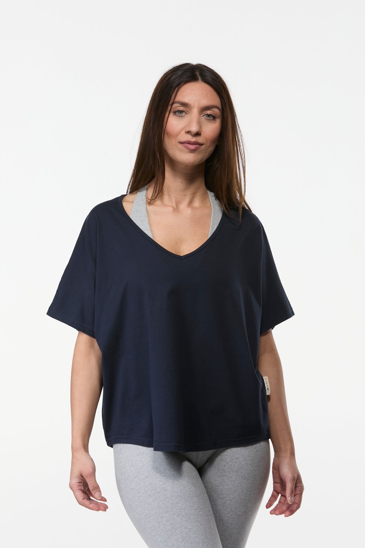 Women’s navy organic cotton yoga top with short sleeves and relaxed fit styled with grey leggings