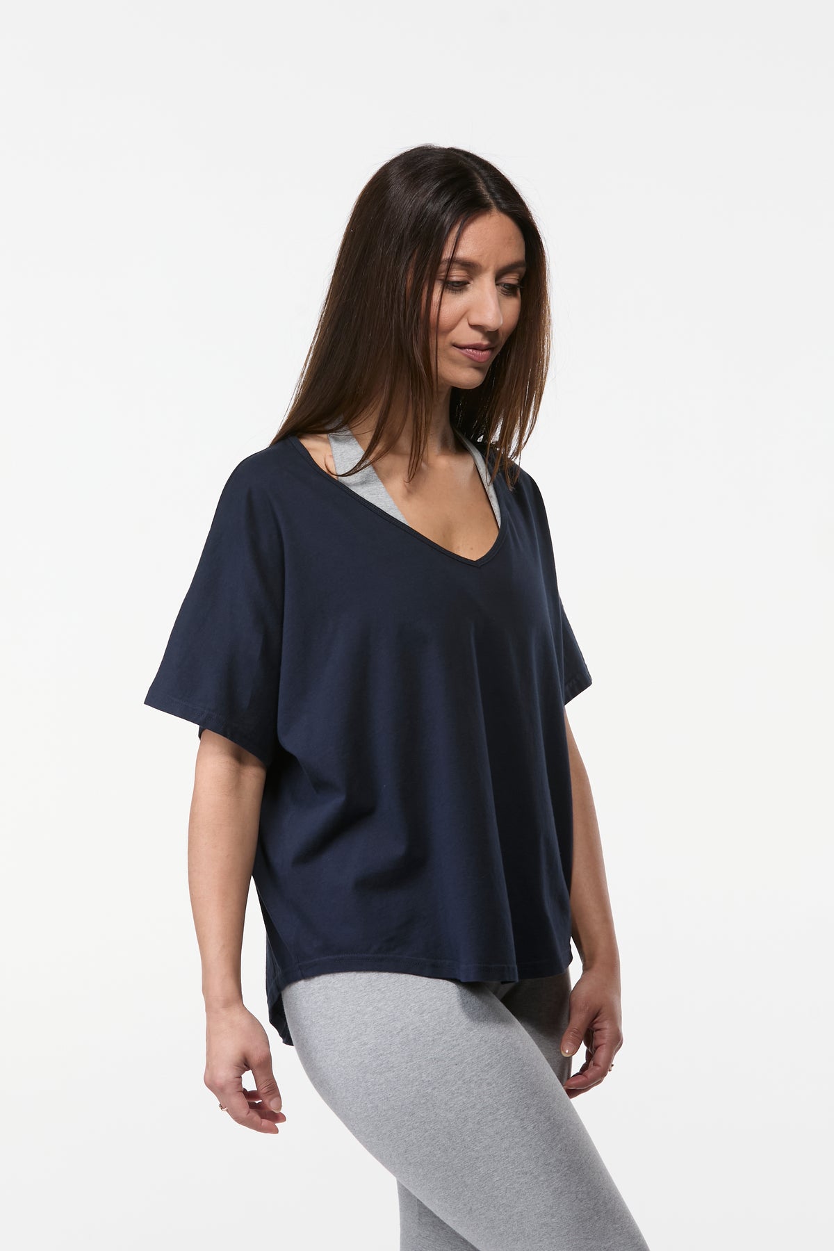 Side front view of women’s navy organic cotton yoga tee with loose fit and soft breathable fabric
