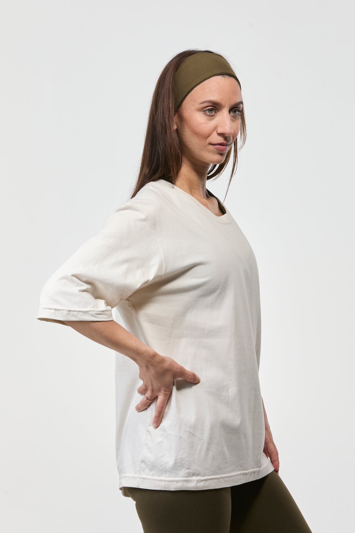 Woman styling a oat oversized 3/4 sleeve tee with army green leggings, loose comfortable fit for studio and lounge wear
