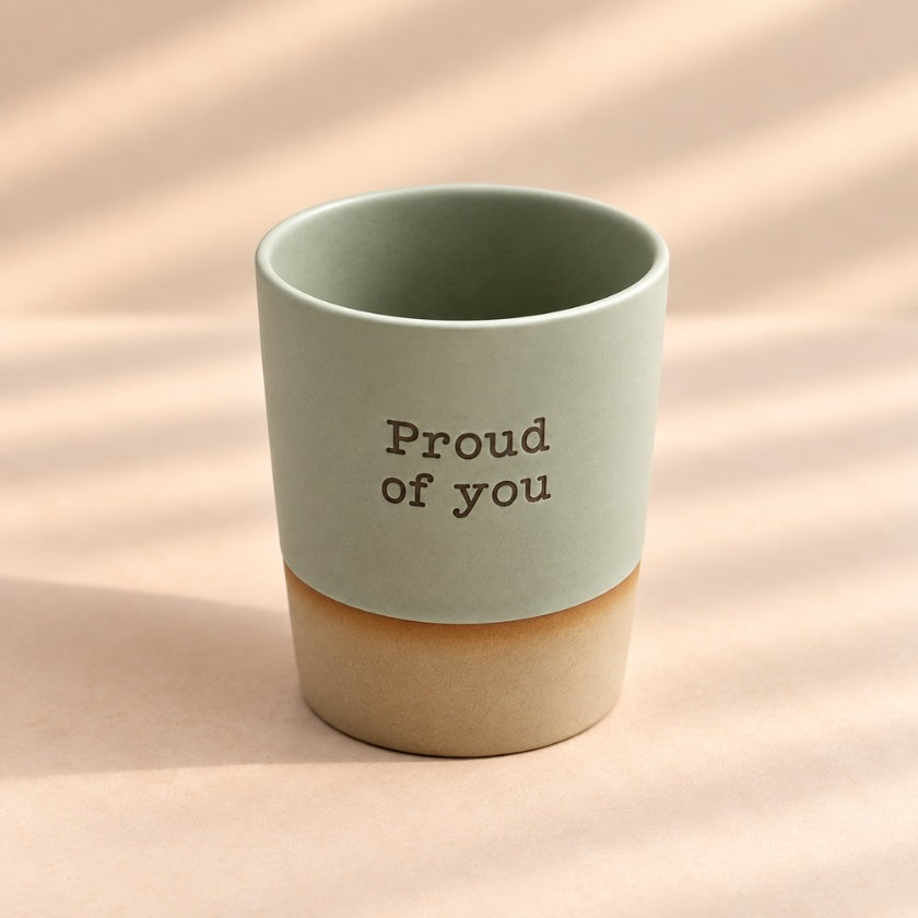 Proud of You hand-glazed ceramic mug in soft sage green with earthy natural-toned base.