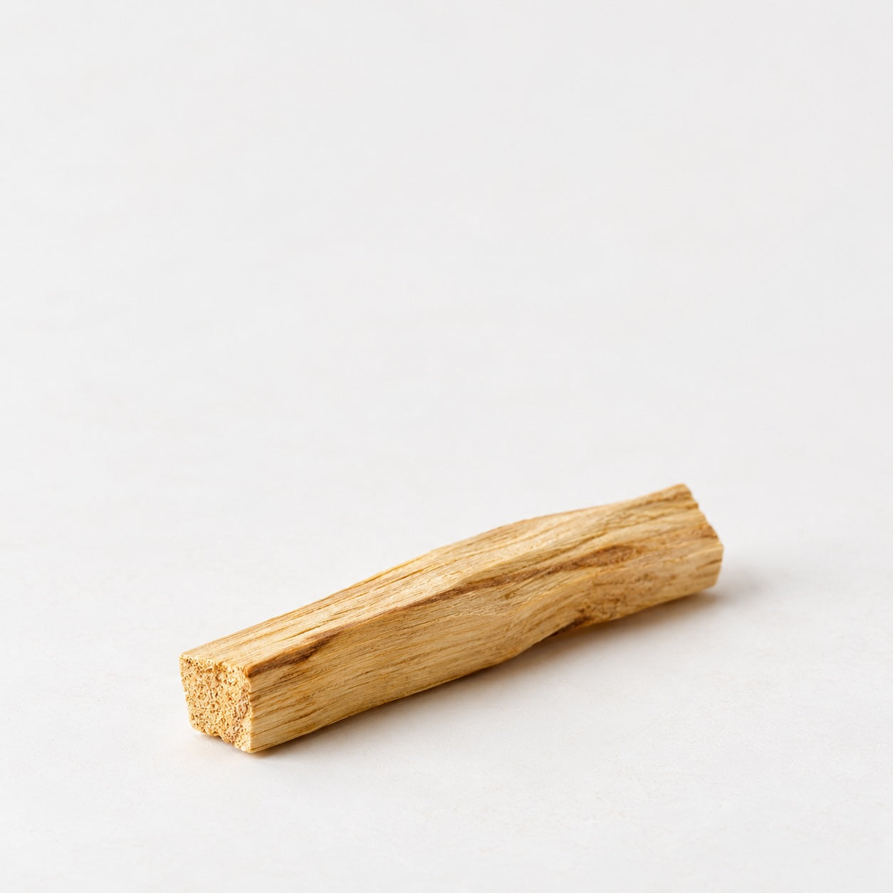 Palo Santo wood stick with natural grain on a neutral background.