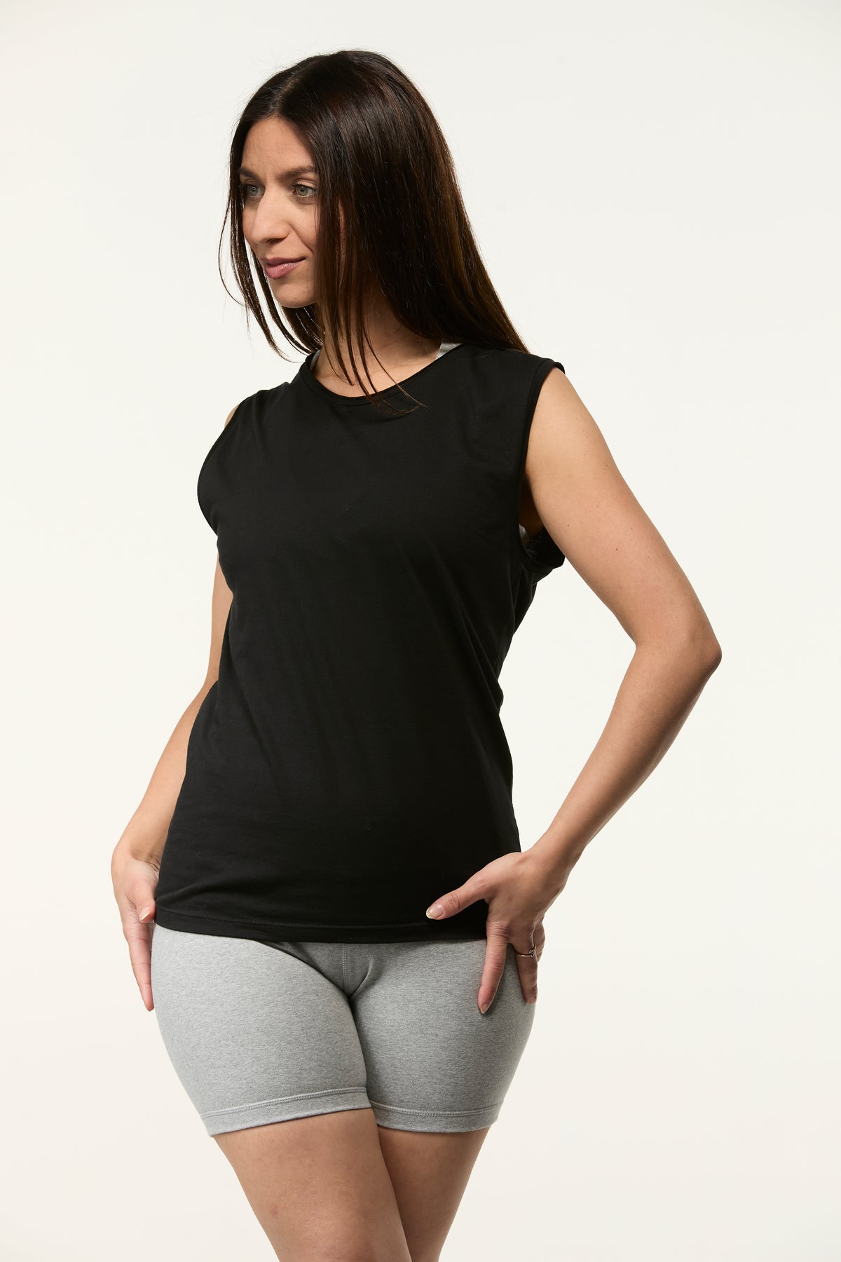 Woman wearing the Slim Fit Tank in black with grey shorts, fitted tank for yoga and everyday wear