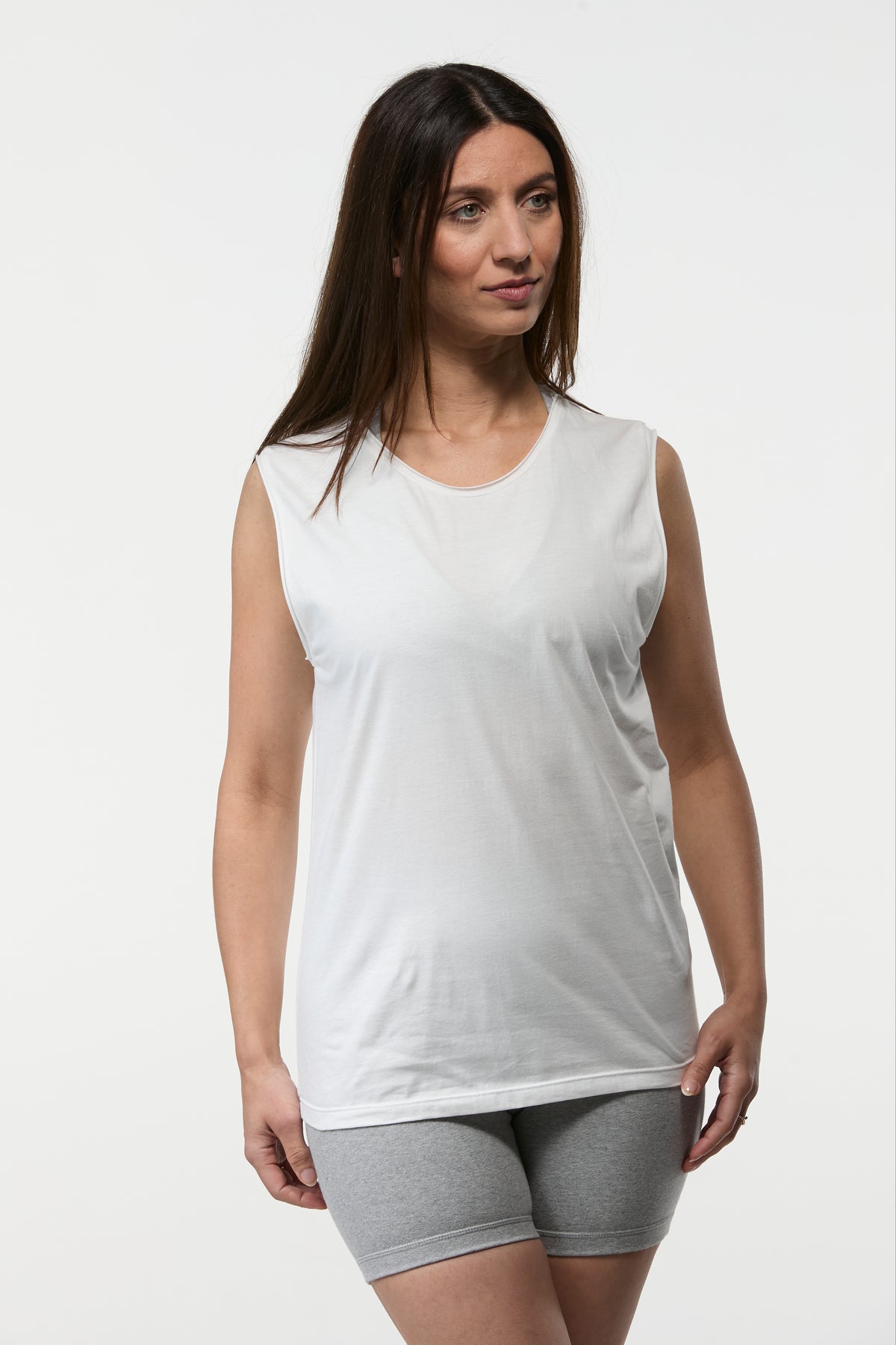 Woman wearing the Slim Fit Tank in white with grey shorts, fitted tank for yoga and everyday wear