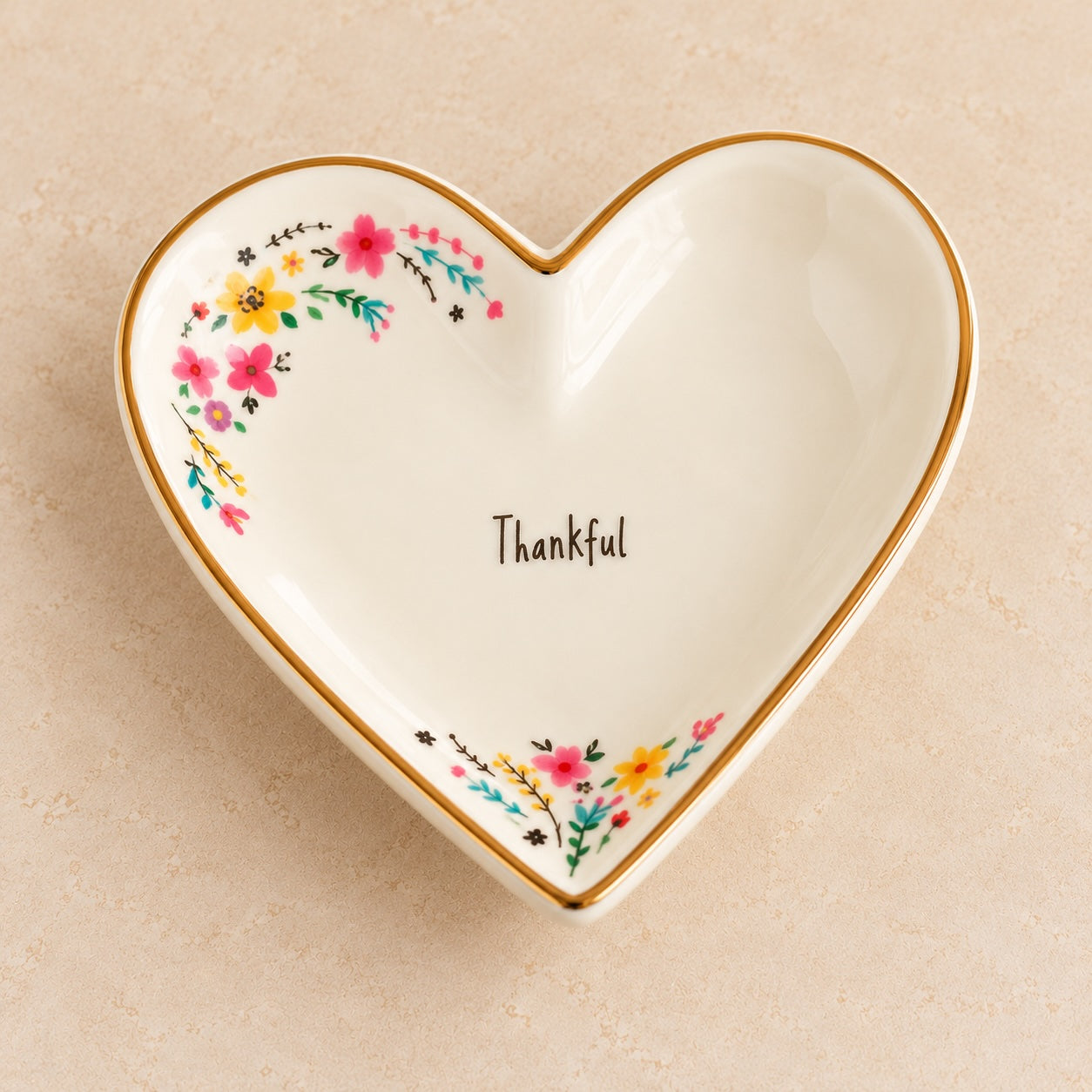 Large cream ceramic heart trinket dish with Thankful lettering, colourful floral artwork and gold-toned rim.