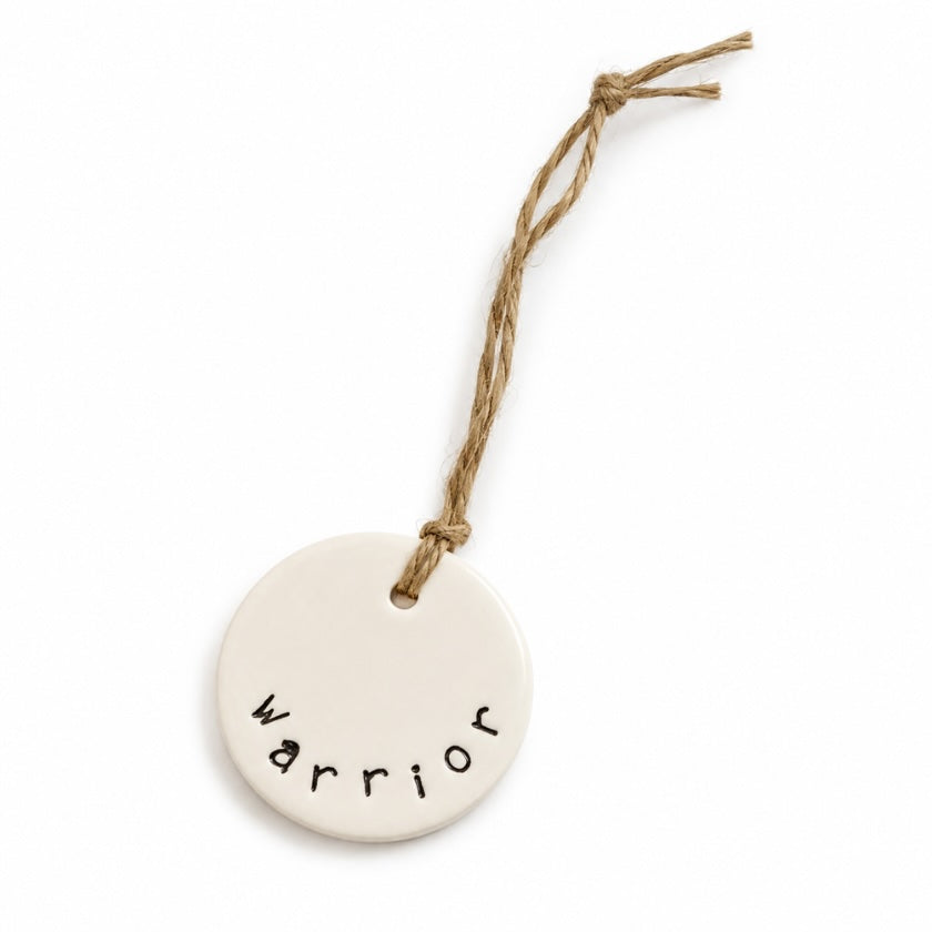 Luna and Soul Warrior handmade ceramic tag with jute twine on white background.