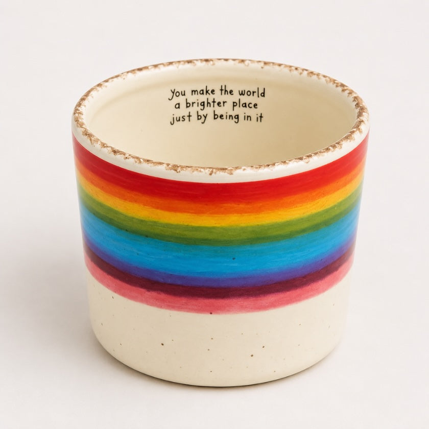 Ceramic planter with vibrant rainbow stripe design and “You make the world a brighter place just by being in it” quote inside the rim.