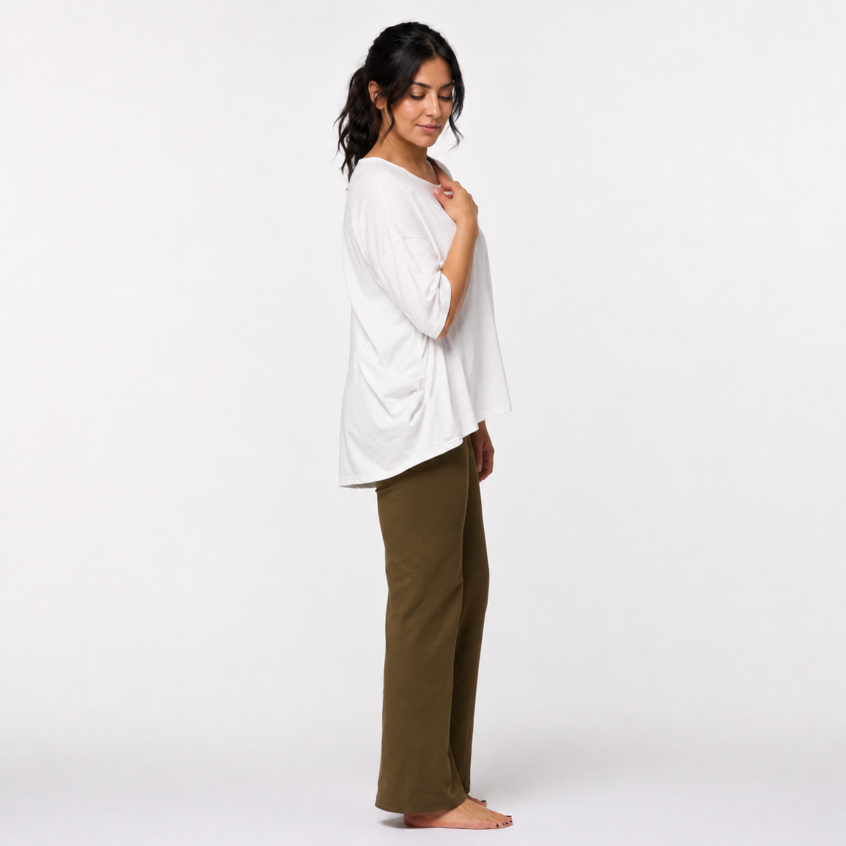 Three-quarter front view of off-white organic cotton Zen yoga top showing fabric drape