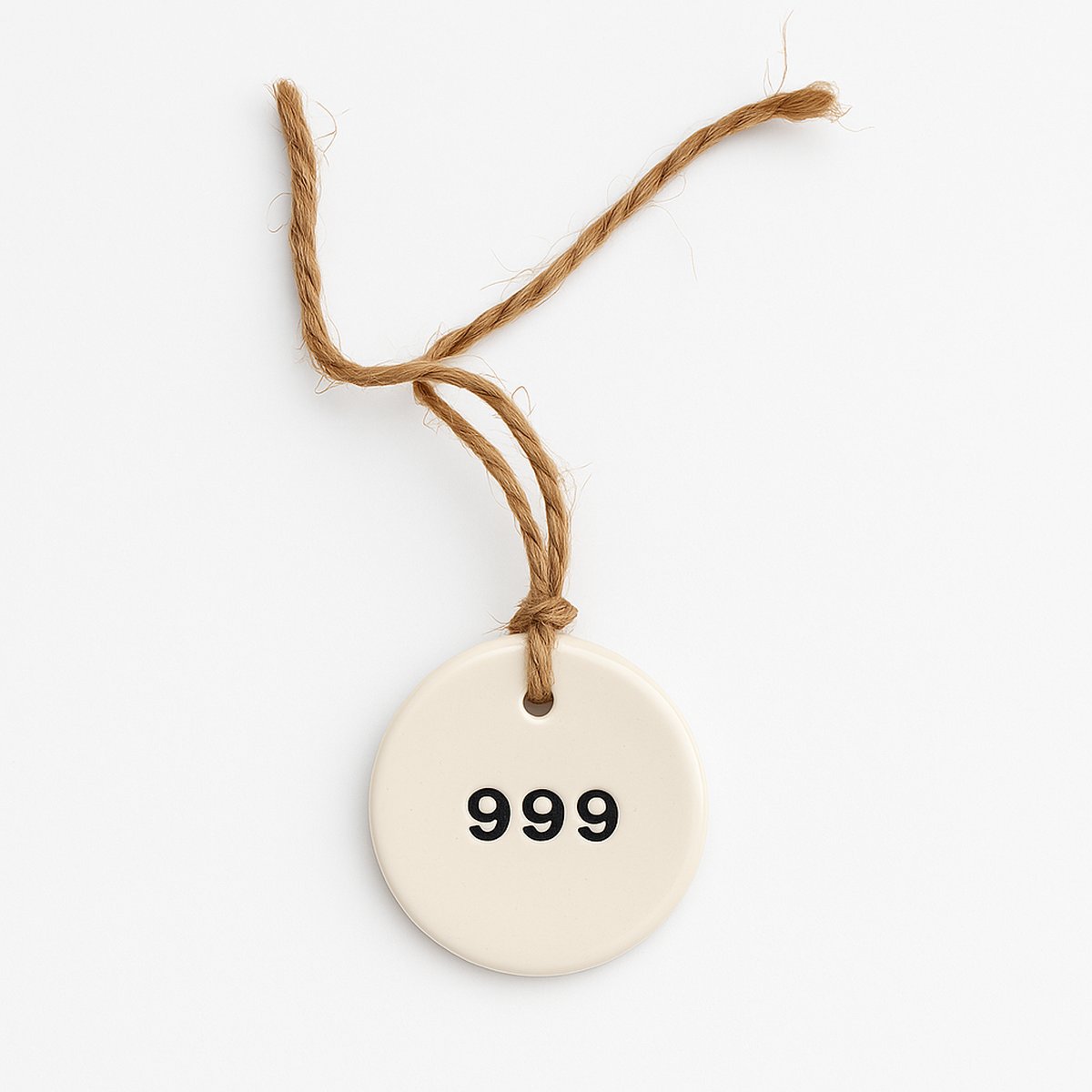 Alt Text: Ceramic tag with the number 999 symbolising completion and fresh starts.