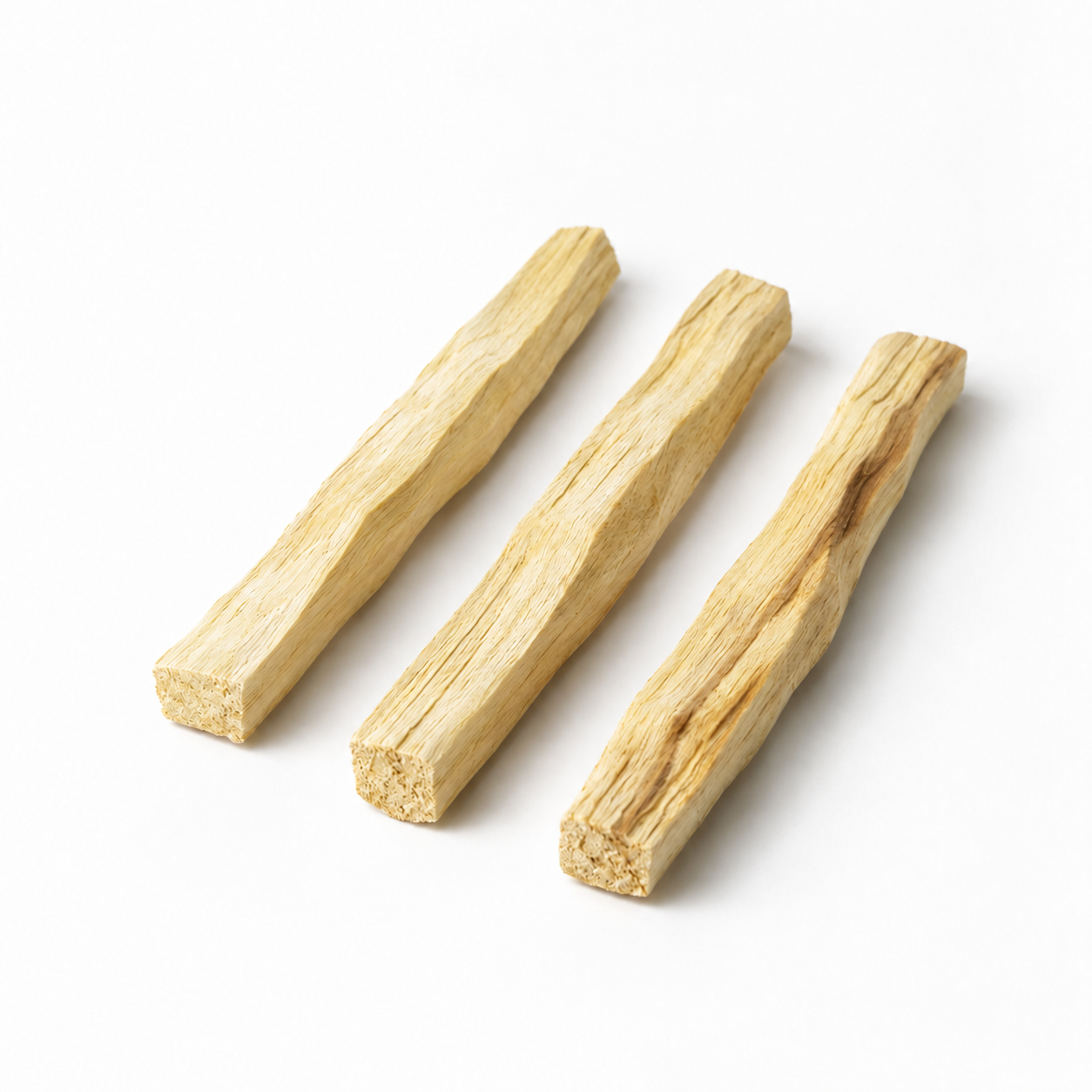 Three unburnt Palo Santo wood sticks arranged side by side on a clean white background