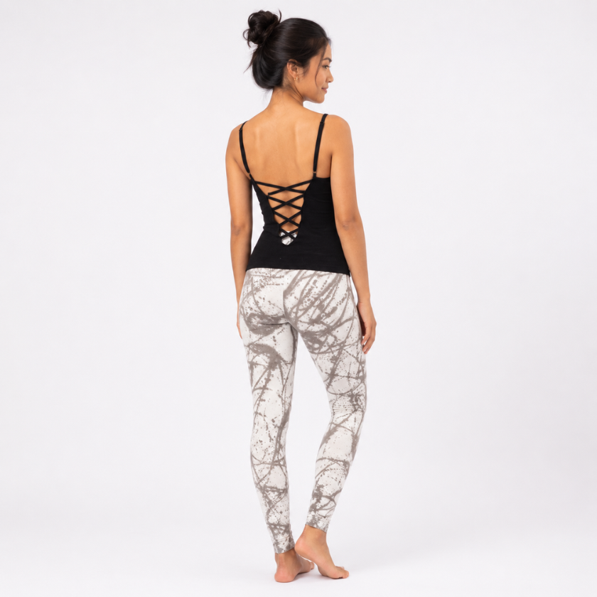 Southeast Asian model wearing the Luna &amp; Soul black zigzag strap top with crisscross back detail and grey scribble print yoga leggings, shown from the back on a clean studio background