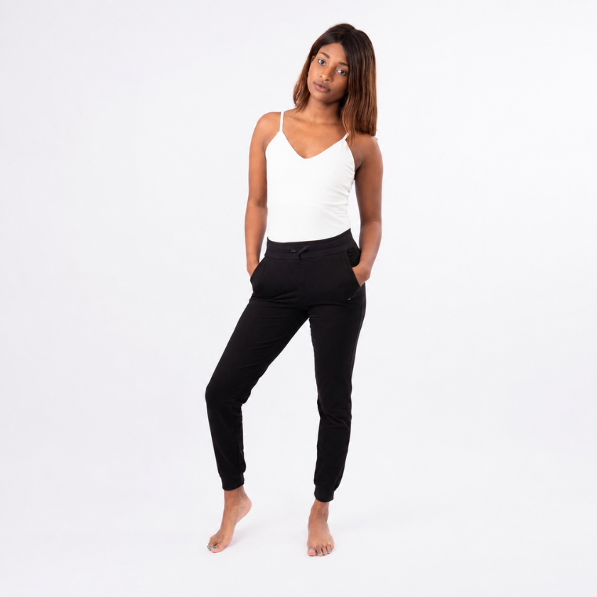 Model wearing the Luna &amp; Soul white zigzag strap top with black organic cotton jogger pants, shown from the front on a clean studio background.