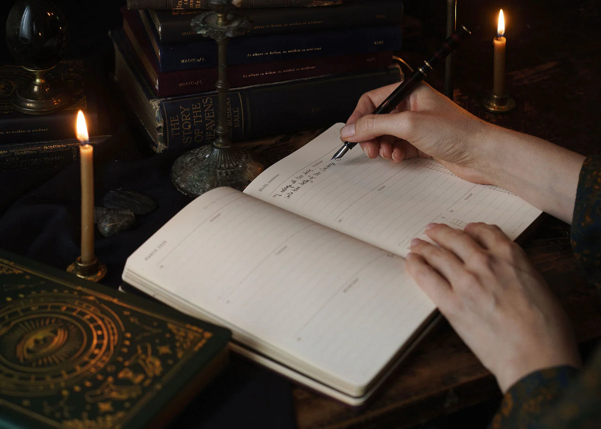 Open pages of the Magic of I 2026 astrological almanac being used for journaling