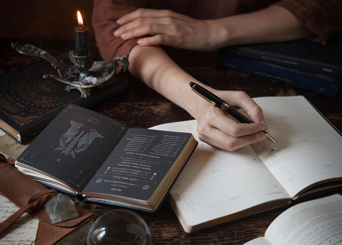Magic of I 2026 astrological planner in black open to weekly view