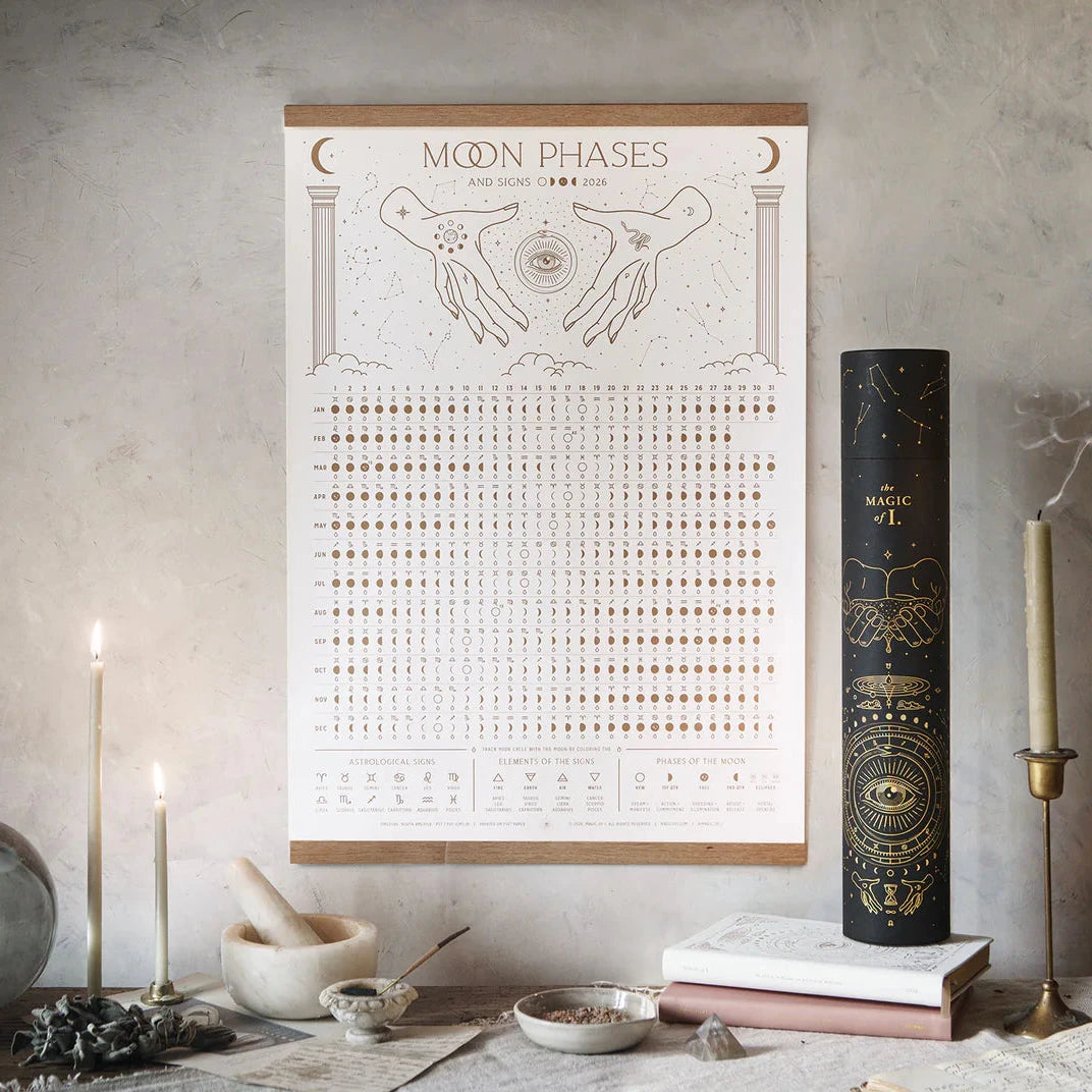 Magic of I 2026 Moon Phases and Signs Calendar hanging on wall with ritual setup and candles