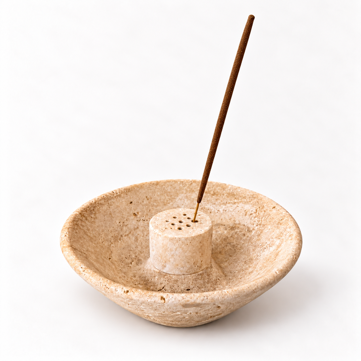 Natural beige travertine stone incense holder bowl with a raised central holder featuring multiple holes and a long brown incense stick, photographed on a clean white background.