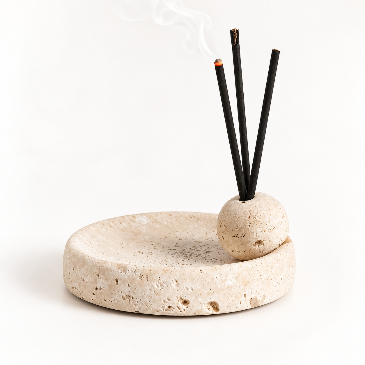 Cream natural stone incense holder with a round tray and matching spherical incense holder, displaying three black incense sticks against a soft white background.