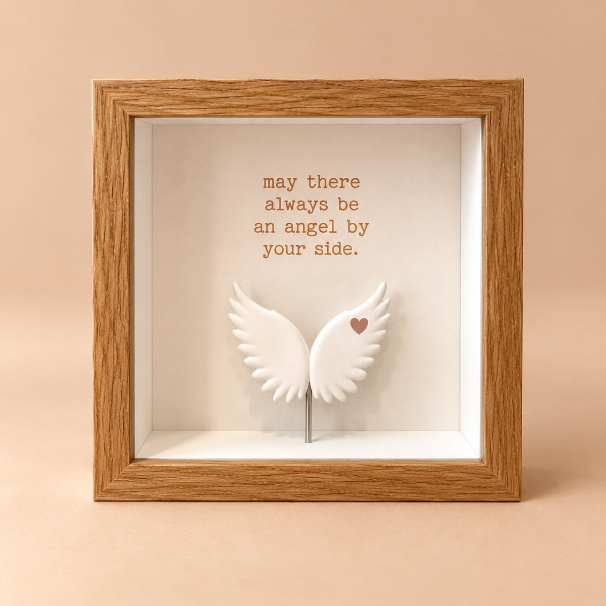 Square oak finish 3D shadowbox frame with the quote “may there always be an angel by your side” above raised white angel wings.