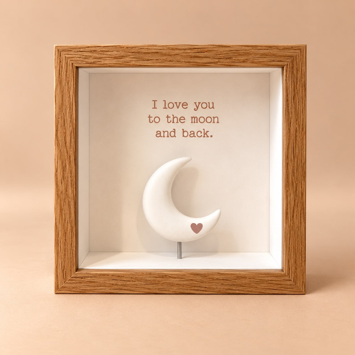 Oak finish 3D shadowbox frame with “I love you to the moon and back” quote above a raised white crescent moon with a small blush heart.