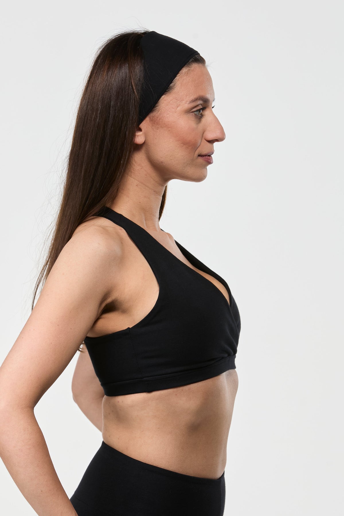 Side view of black cotton sports bra showing supportive fit, breathable fabric, and feminine shape