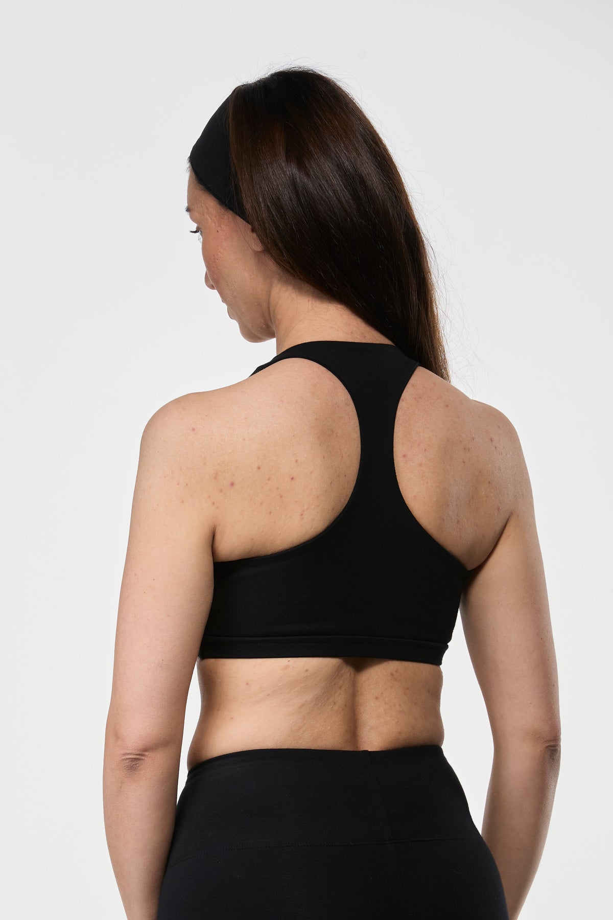 Side view of black cotton sports bra showing supportive fit, breathable fabric, and feminine shape